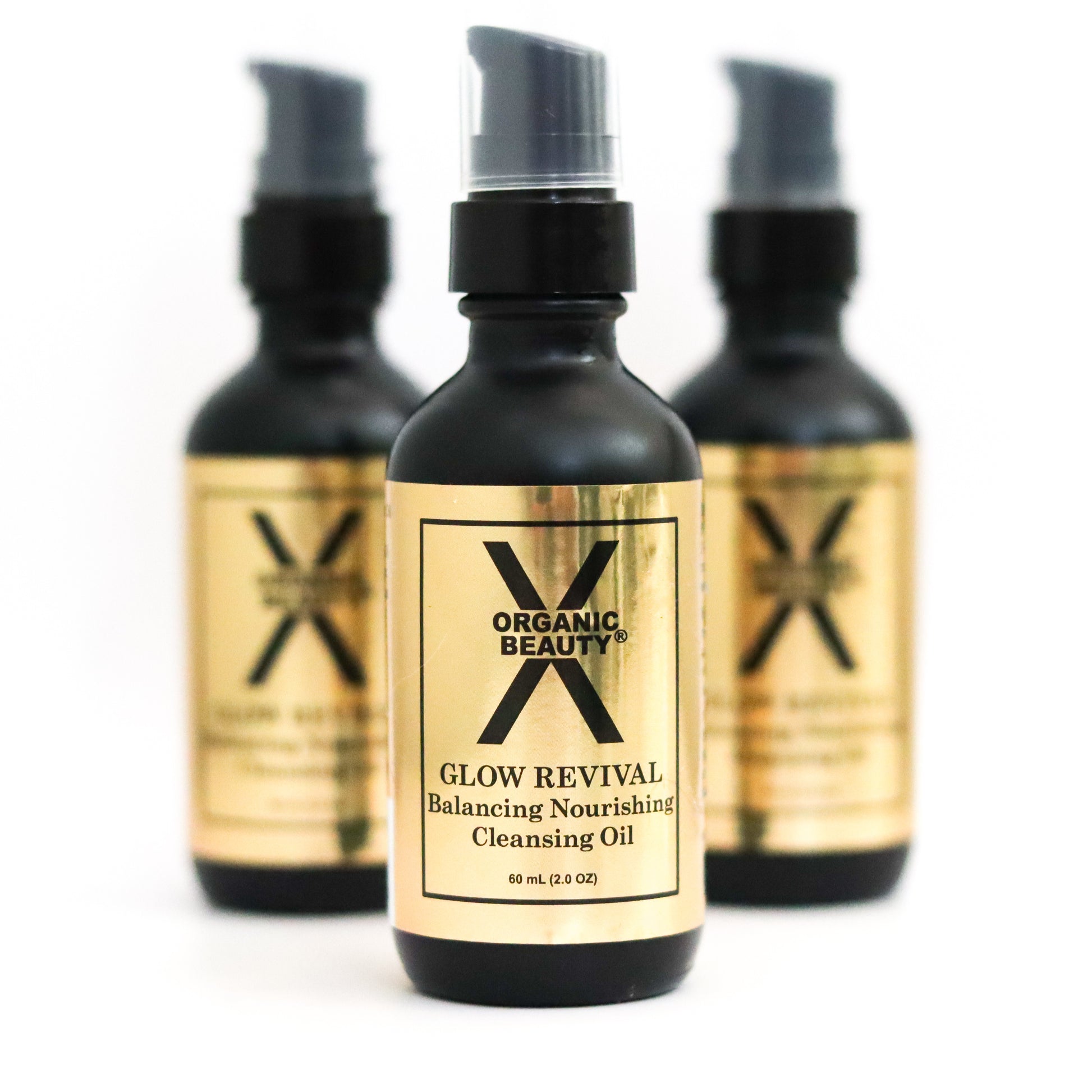 Three bottles of Organic Glow Revival Cleansing Oil on a white background