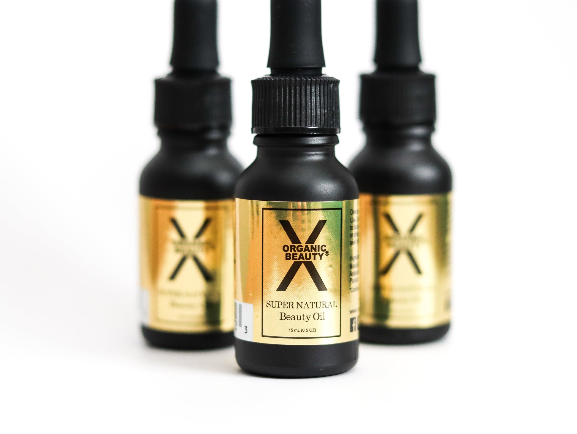Three 1/2 ounce bottles of Super Natural Beauty Oil on a white background.