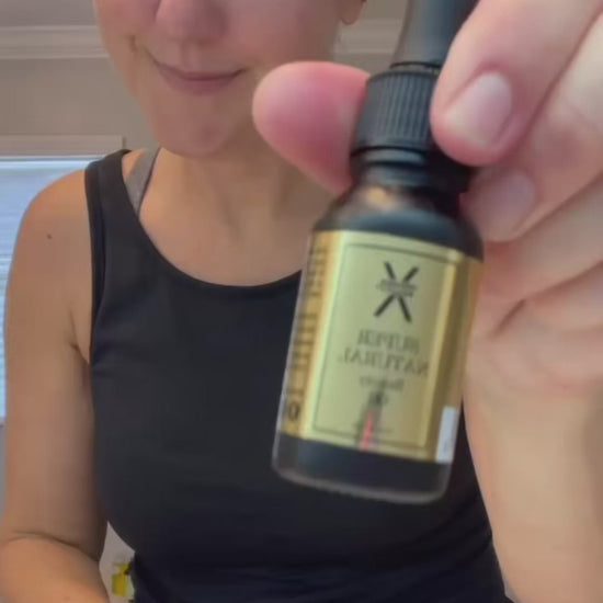 A video of a young woman showing Super Natural Beauty Oil benefits