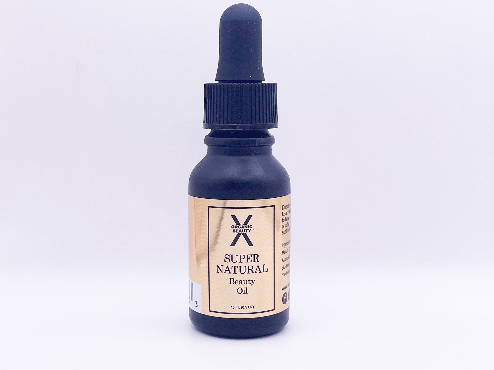 A front view of Super Natural Beauty Oil. A black bottle with a gold label.